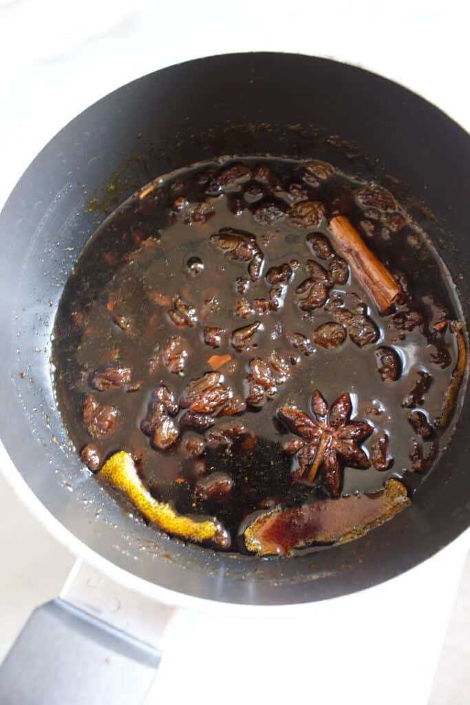 een steelpan met gesuikerde inmaakbrandewijn, specerijen en rozijnen om boerenjongens te maken
