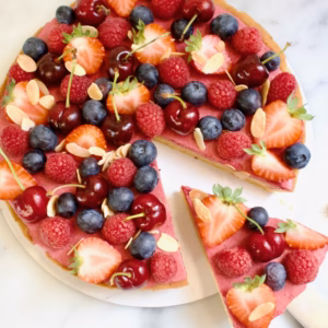 bosvruchten bavarois taart met verse kersen, aardbeien, frambozen en bosbessen erop.