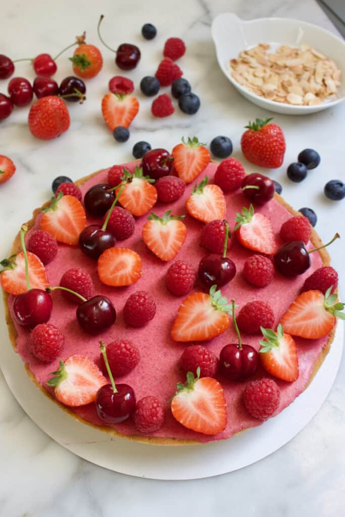 bosvruchten bavarois taart decoreren met vers fruit (gehalveerde aardbeien, frambozen en kersen)