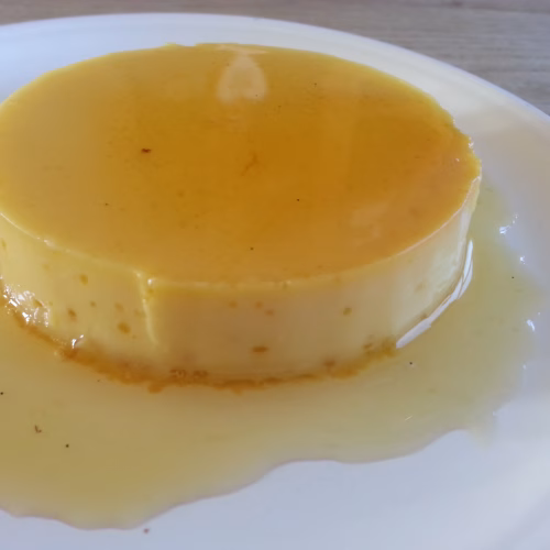 gebakken flan met karamel op een wit bord.