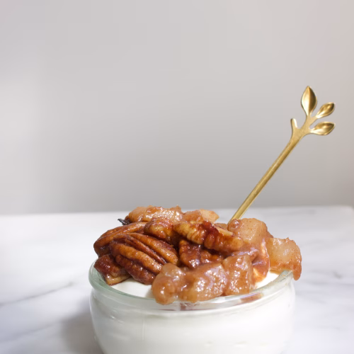 Griekse yoghurt met peer en pecannoten in een glaasje als toetje.