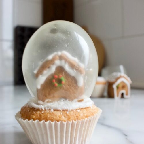 sneeuwbol cupcake met gelatine ballonnen en peperkoeken huisjes