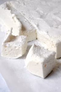 plaat zelfgemaakte marshmallow met blokjes eruit gesneden.