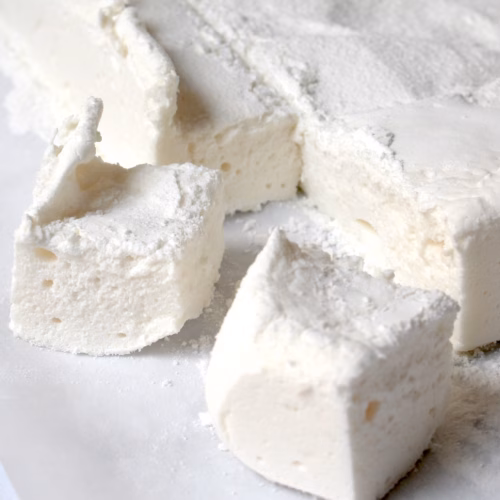 plaat zelfgemaakte marshmallow met blokjes eruit gesneden.