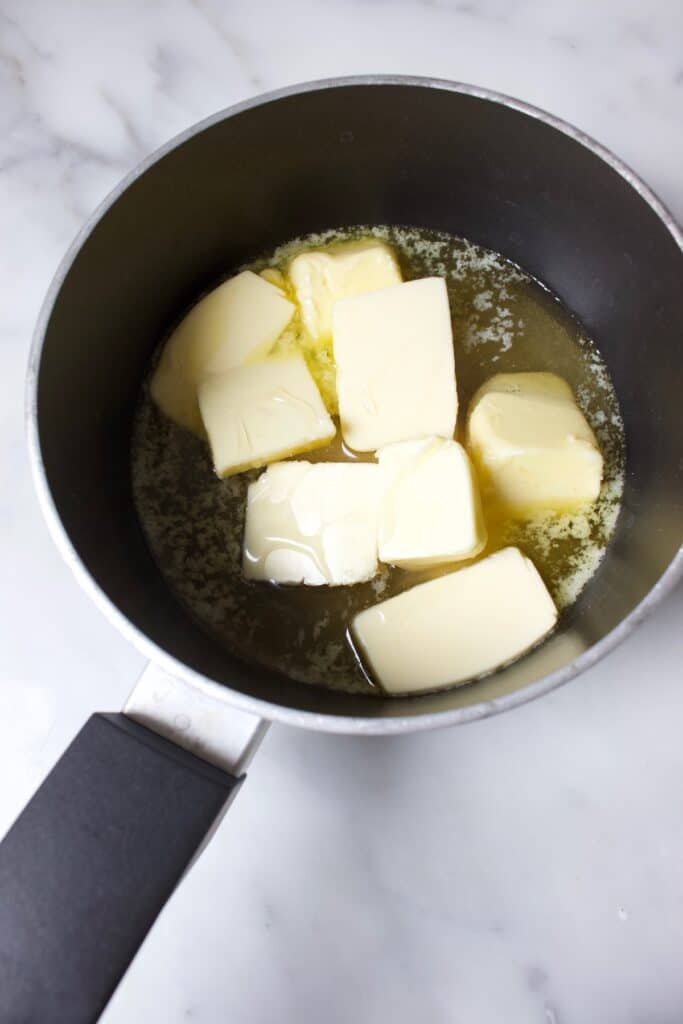 boter en de vloeibare ingredienten voor flapjacks met pecannoten in een pan om te smelten