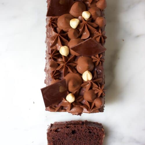 bovenkant van een chocolade cake met toefjes chocolade creme en hazelnoten