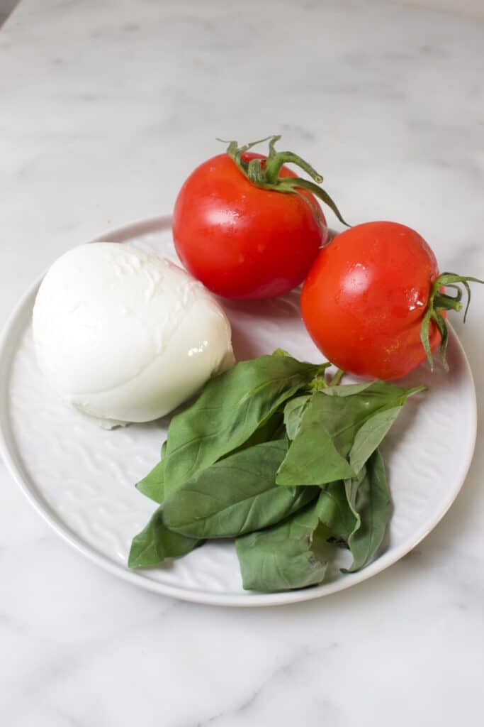 bord met mozzarella, tomaat en basilicum