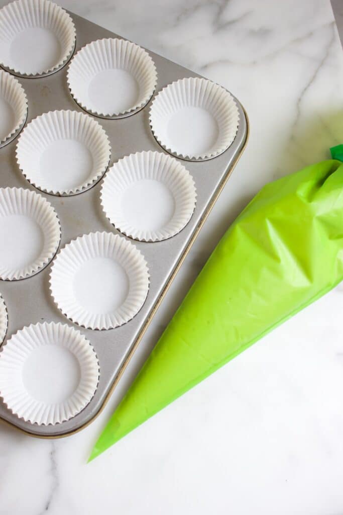 cupcake vorm en cupcakebeslag in een groene spuitzak