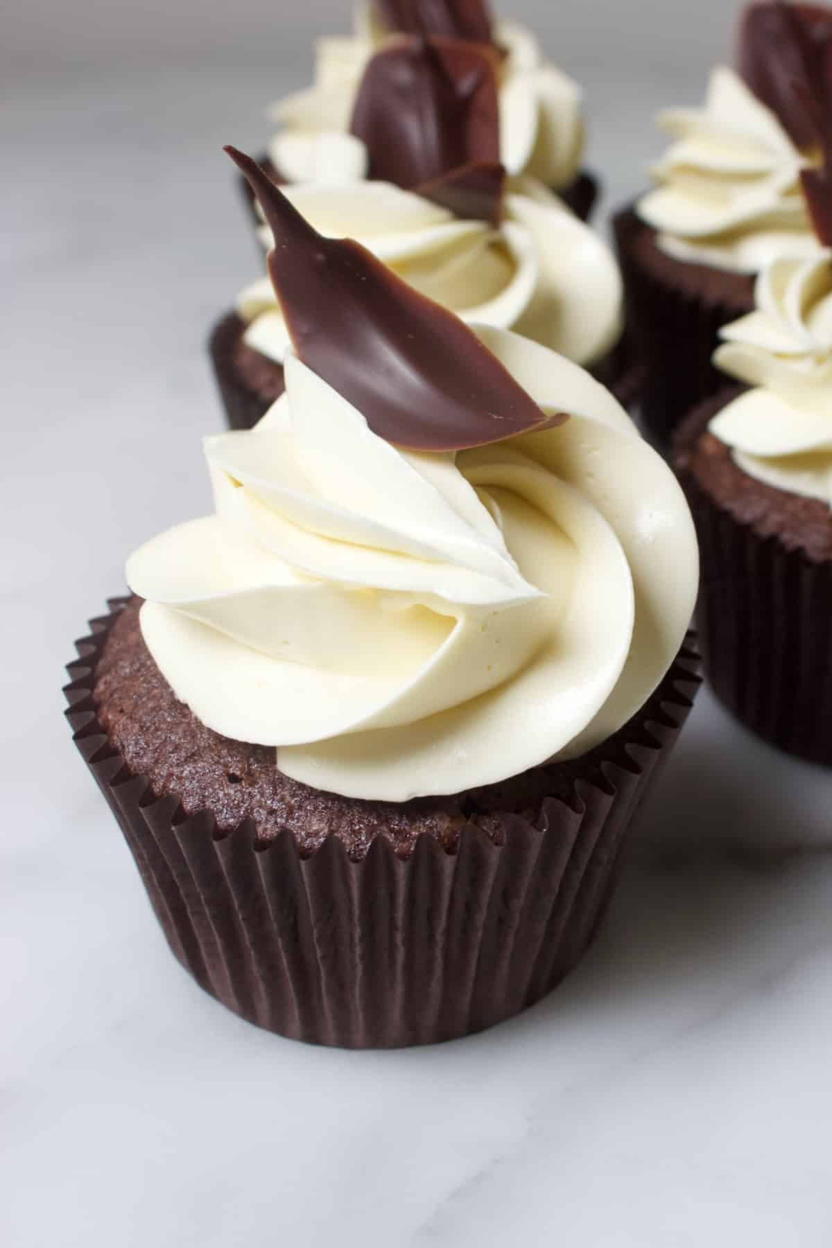 chocolade cupcakes met een witte toef en een chocolade blaadje
