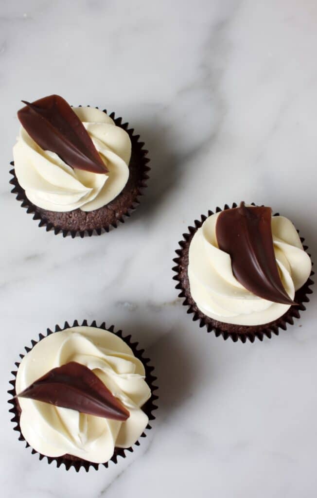 chocolade cupcakes met een witte toppin en chocolade blaadjes