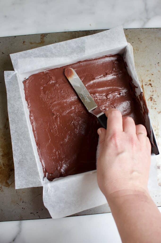 chocolade fudge gladstrijken in een bakvorm bekleed met bakpapier