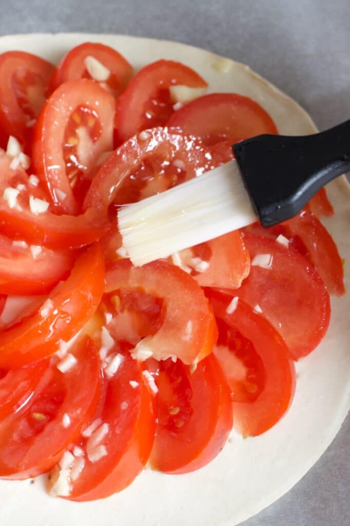 tomaatplakjes bestrijken met knoflookboter