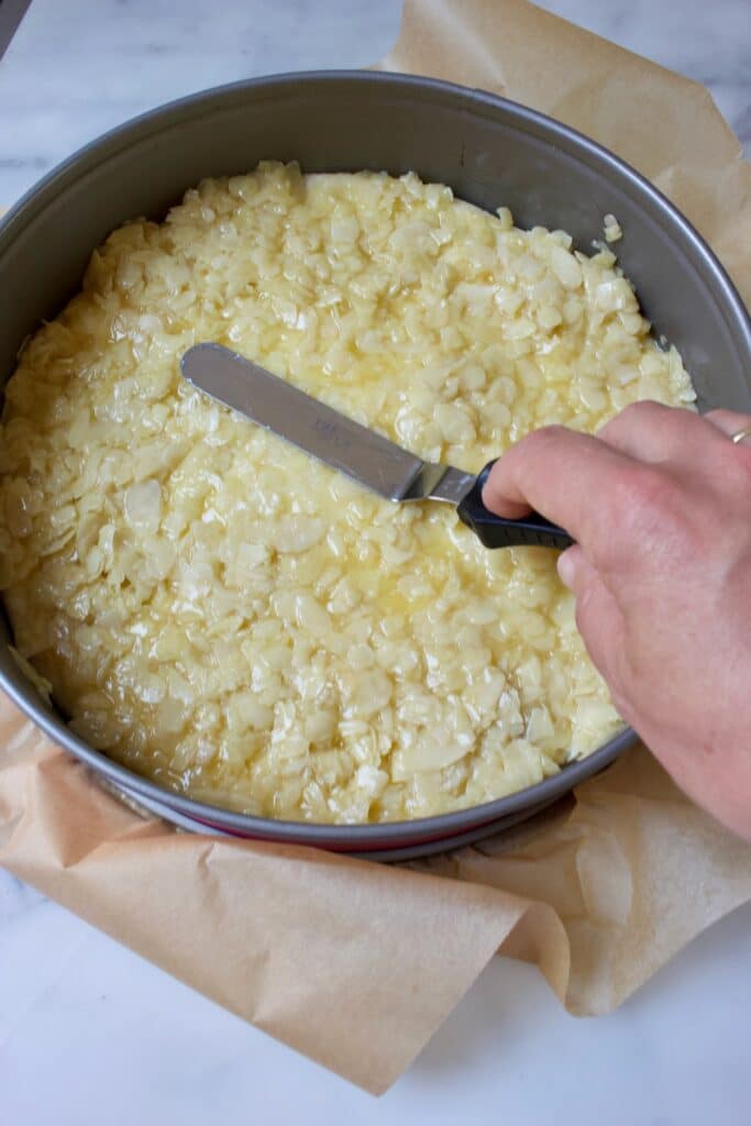 amandellaag aanbrengen op deeg in een springvorm