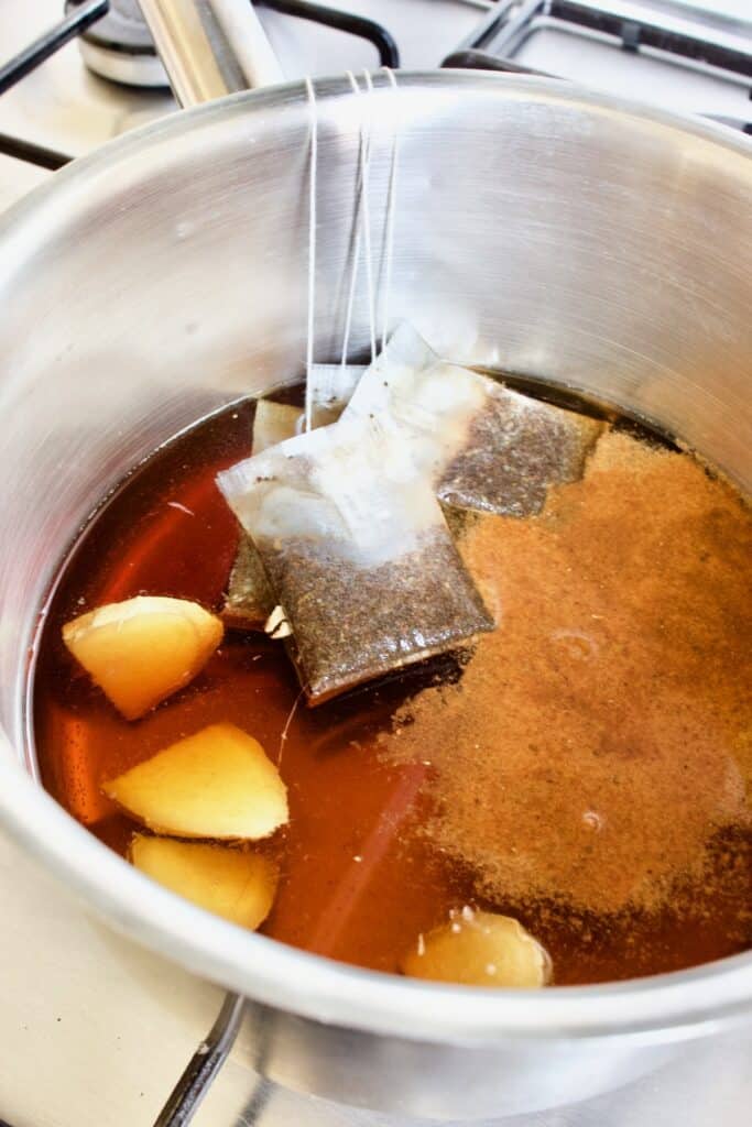 thee zetten in een steelpan met gember en chai masala specerijen