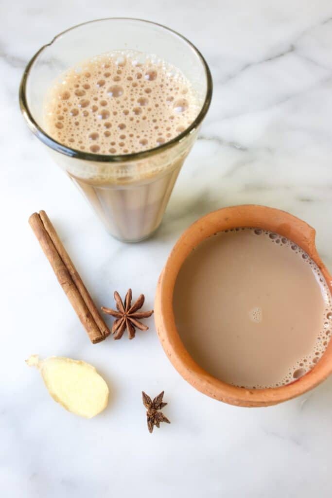 chai in een traditioneel Indiaas chai glas en een traditioneel terracotta potje