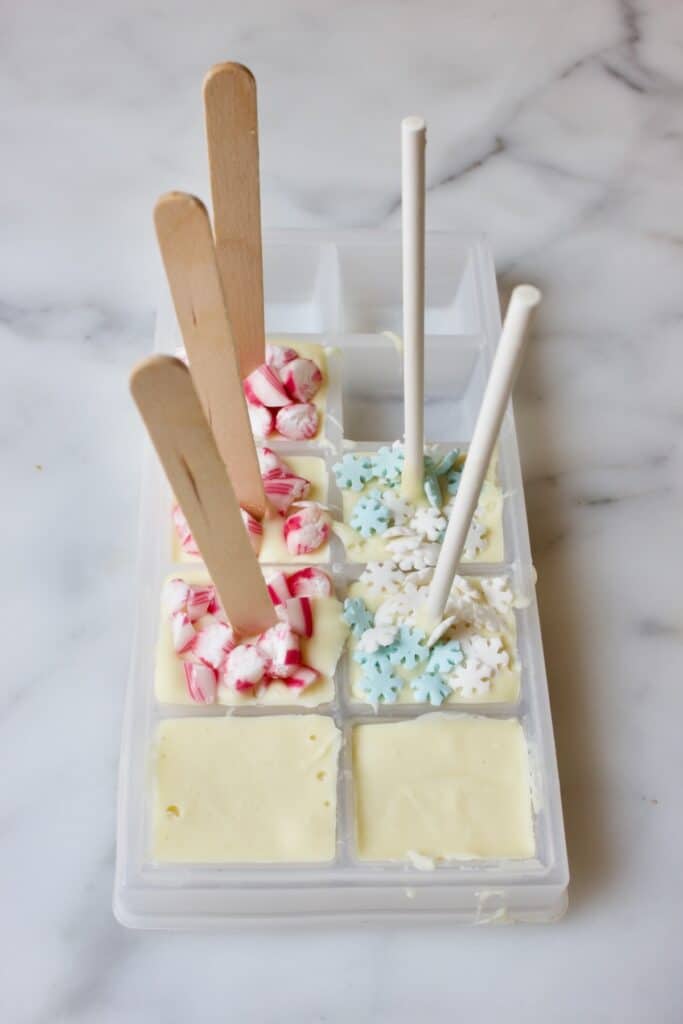 witte chocolade in ijsblokjesvorm voor witte chocolademelk sticks. Gedecoreerd met stukjes candy cane en sneeuwvlok sprinkles