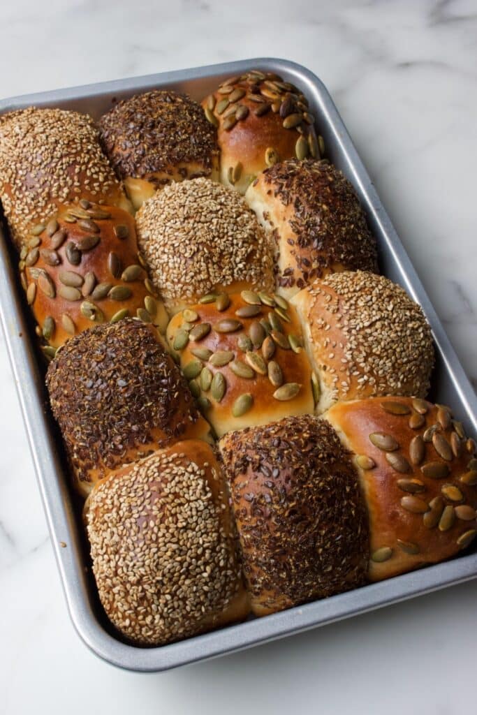 gebakken breekbroodjes met zaden en pitten op de verschillende broodjes (sesamzaad, lijnzaad en pompoenpitten), in de bakvorm, net uit de oven na het bakken