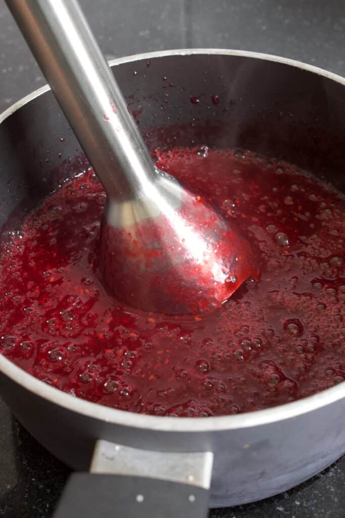 met een staafmixer de frambozensaus pureren