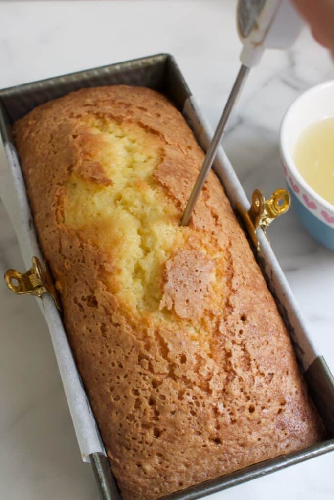 met een prikker gaten prikken in een citroencake