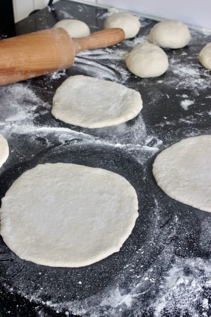 deegbolletjes met een deegroller uitrollen tot ronde pita broodjes