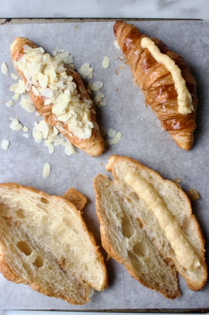proces voor het maken van de amandel croissant. open gesneden, eentje gevuld, eentje dicht geklapt en eentje volledig afgemaakt met geschaafde amandel erop