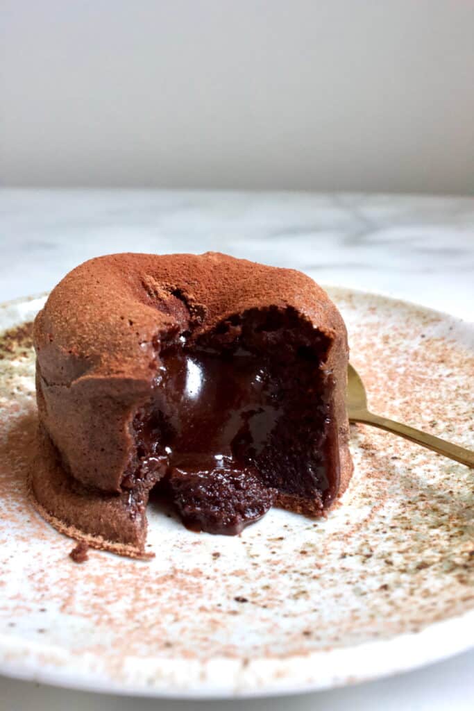 lava cake op een bord waarbij de vloeibare binnenkant zichtbaar is