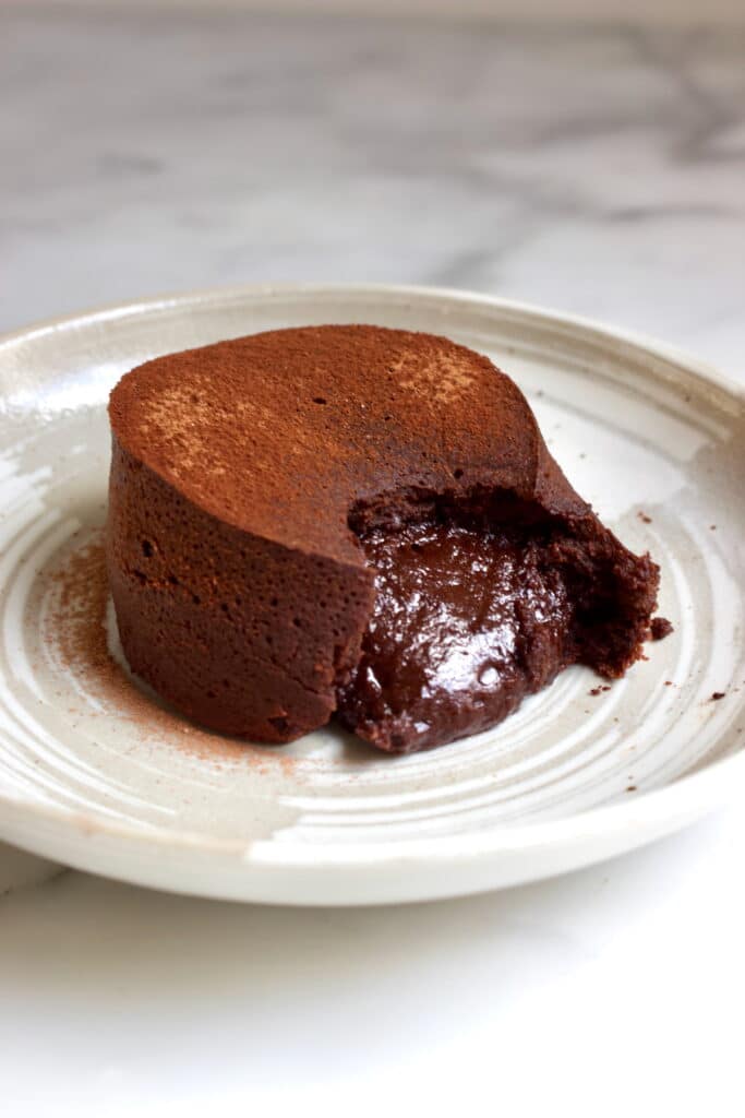 lava cake op een dessertbord waaruit de vloeibare binnenkant loopt