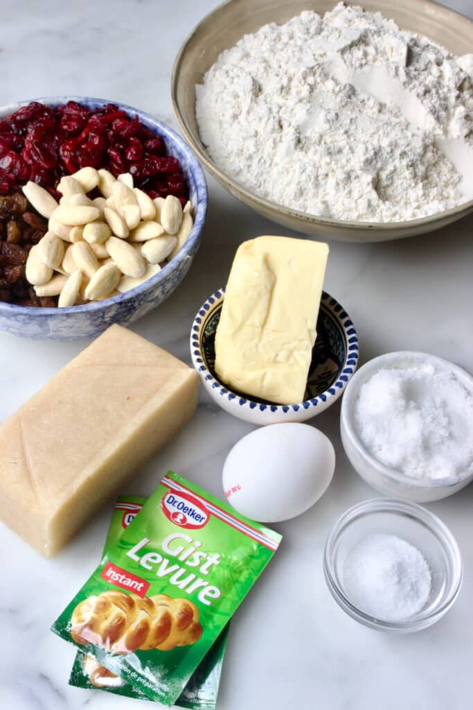 ingredienten voor kerststol: Bloem, boter, basterdsuiker, ei, zout, gist, amandelen, hazelnoten, cranberry's en rozijnen